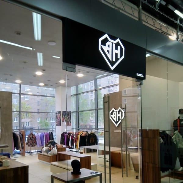 Световой логотип над входом в магазин